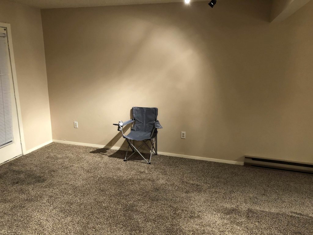 Just a camp chair in a bare living room