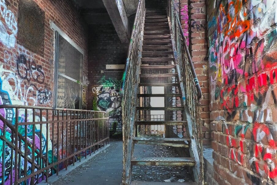 a set of metal stairs and railings within a brick lined landing space