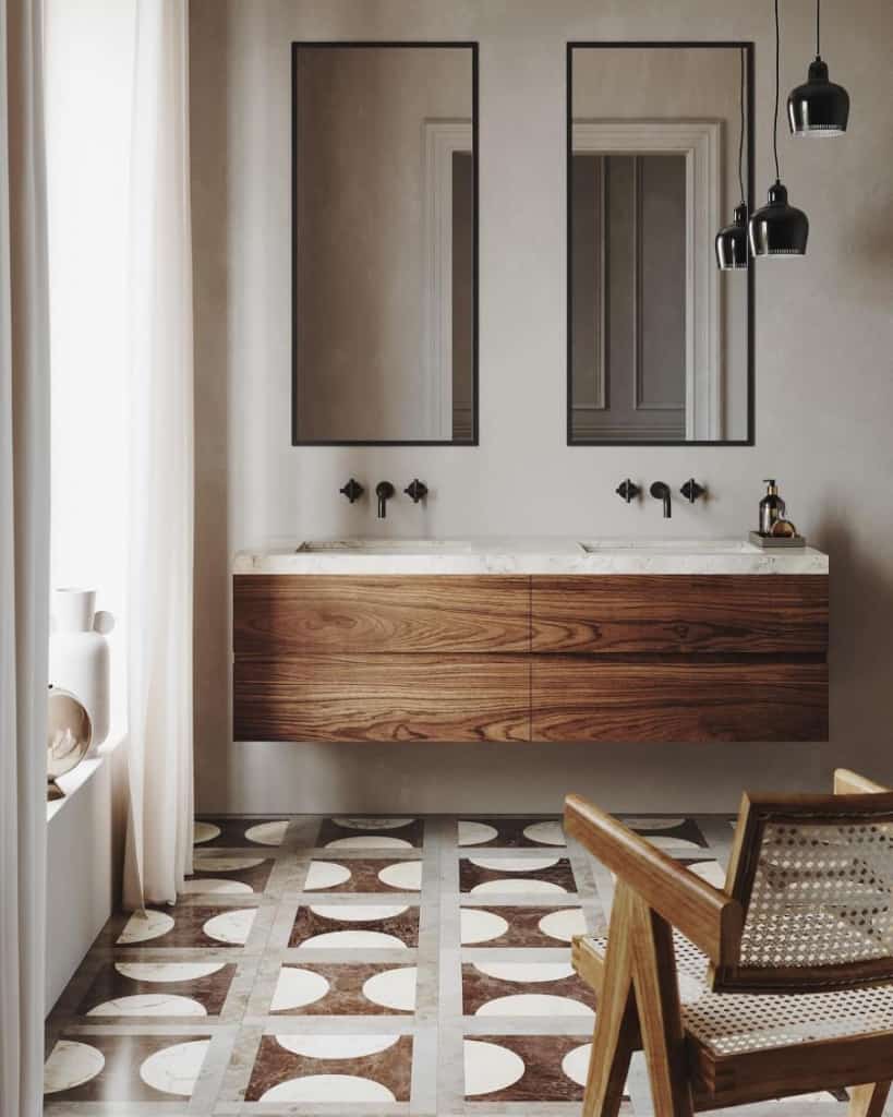 a bathroom setting showing a double sink unit in dark hardwood and gray walls with geometric pattern floor tiles