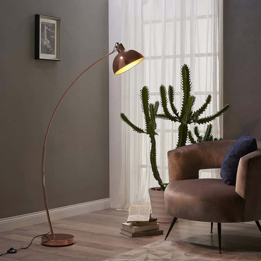 shorter arched floor lamp next to an armchair