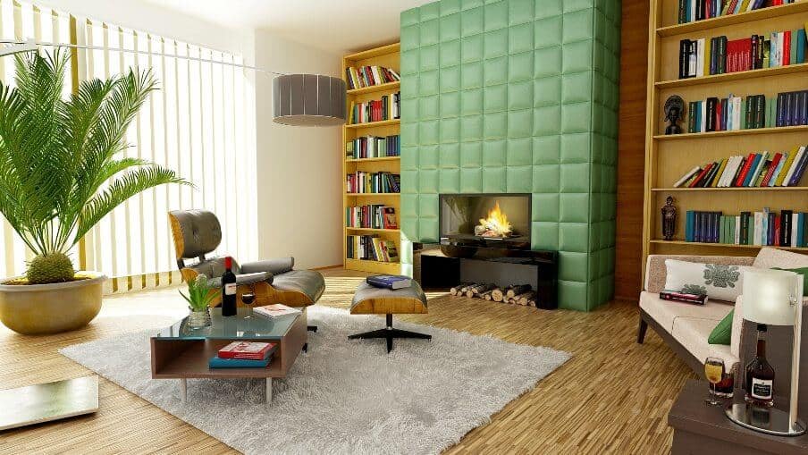 living room with brown floor and bookshelves and green padded finish to chimney breast