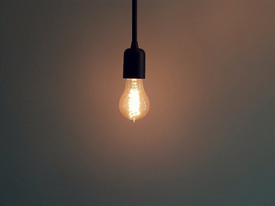 a lit light bulb hanging from the ceiling