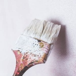 brush applying paint to a wall