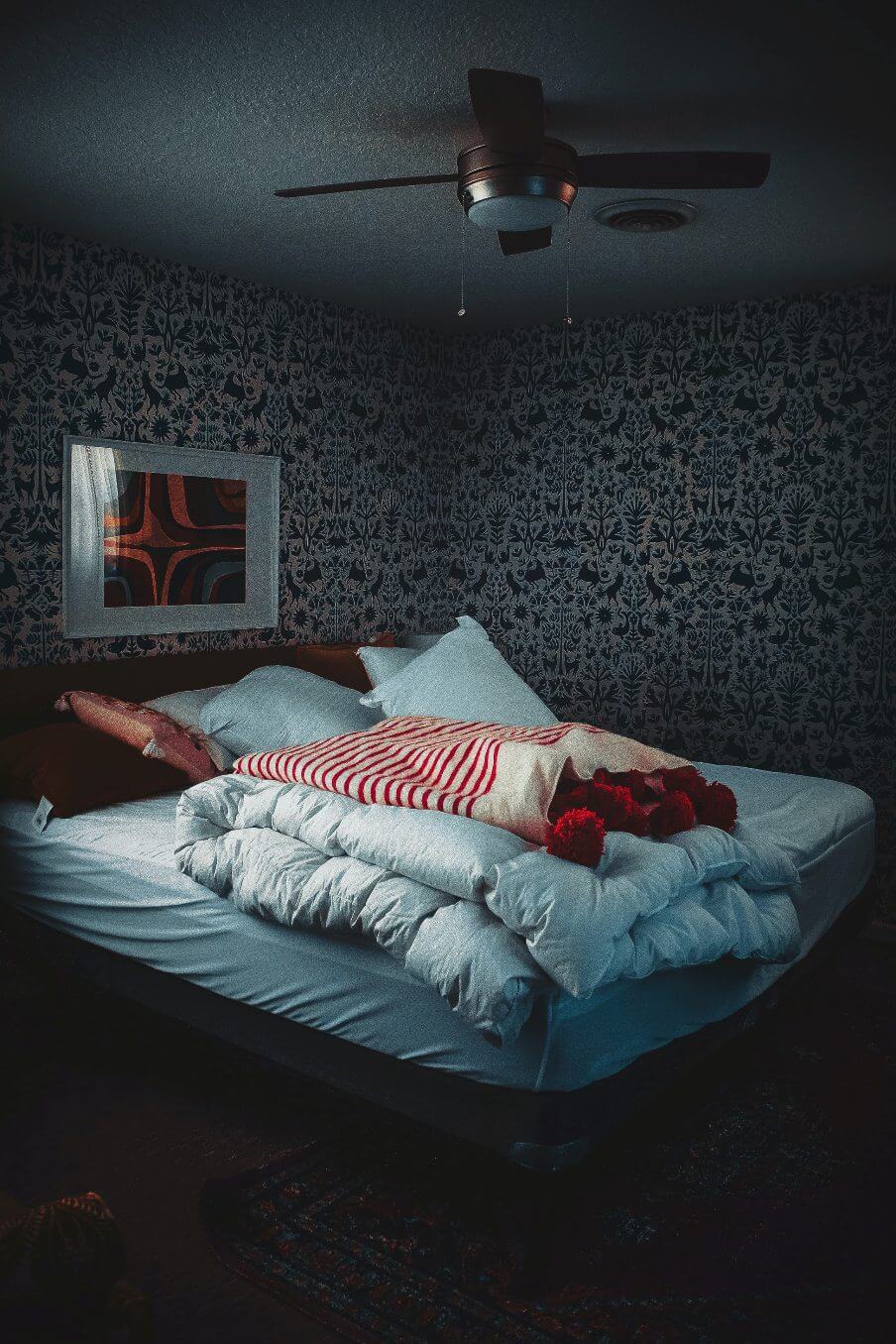 view of a dark bedroom with bed in the centre