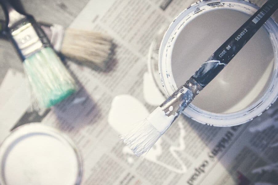 paint can and brushes with white paint